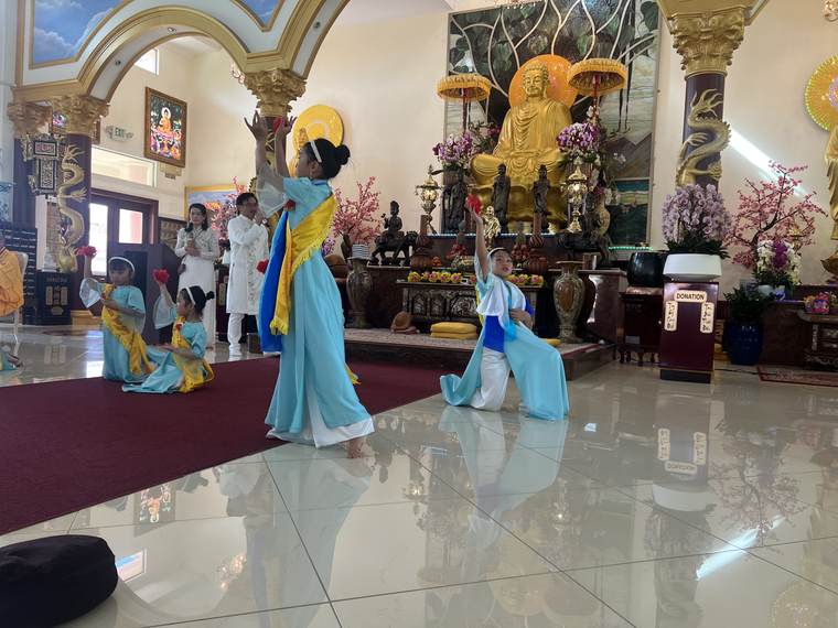 Các em dâng hoa trước tôn tượng Đức Phật trong chánh điện, Vu Lan 2026